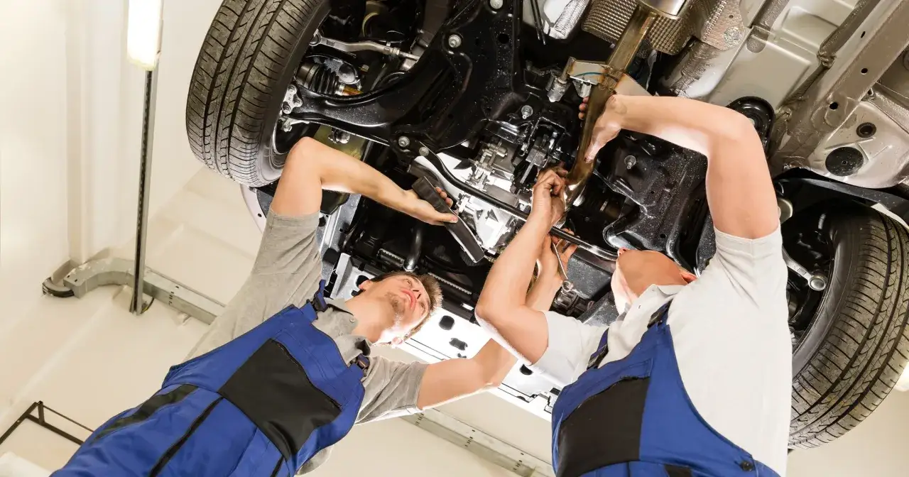Dwóch mechaników pracuje pod samochodem. Zastanawiasz się, ile zarabia kierowca mechanik?